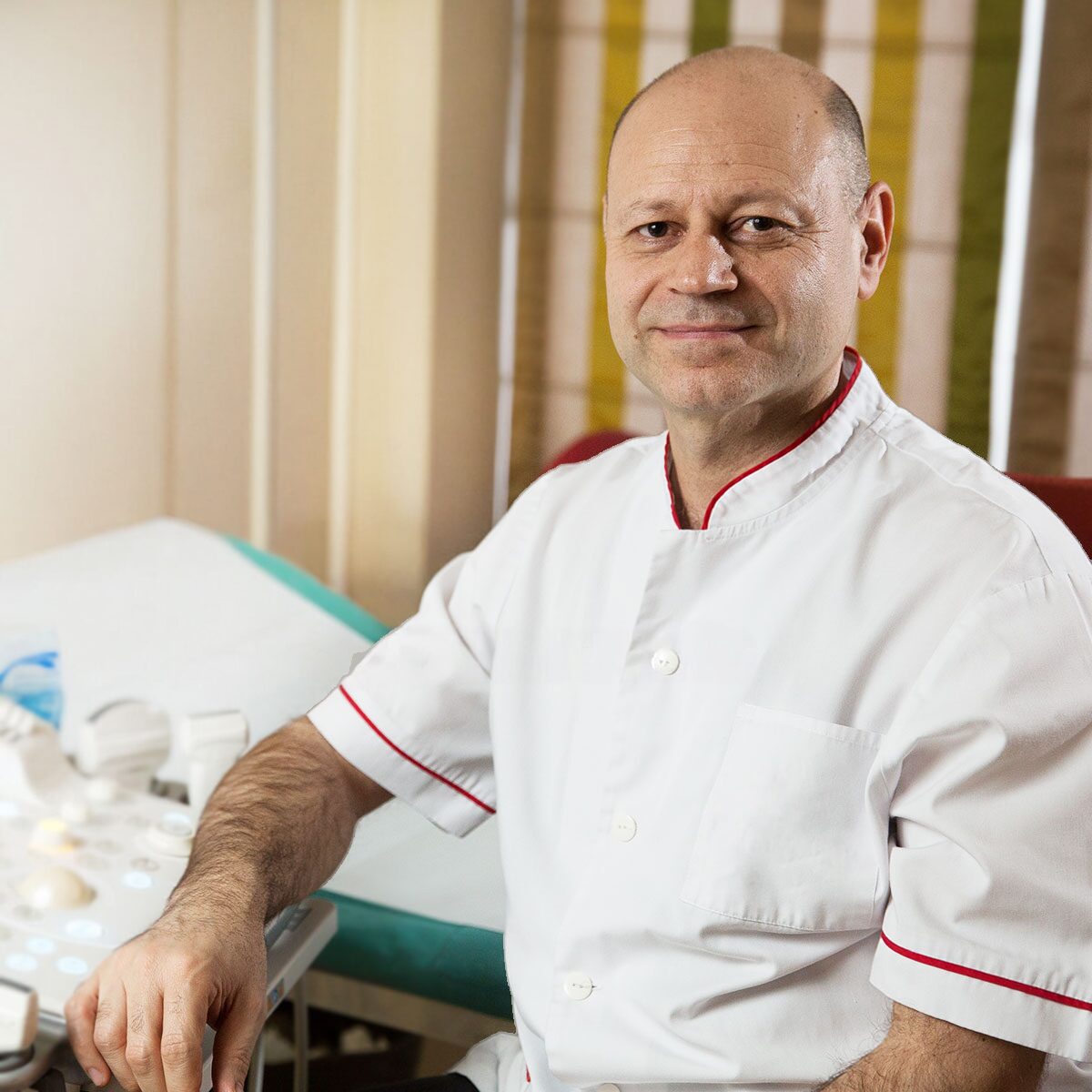 Dr. George Marinescu în cabinetul de ecografie, așezat lângă patul de examinare