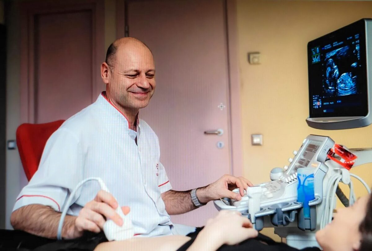 Dr. George Marinescu efectuând o ecografie, cu imaginea pe monitorul ecografului
